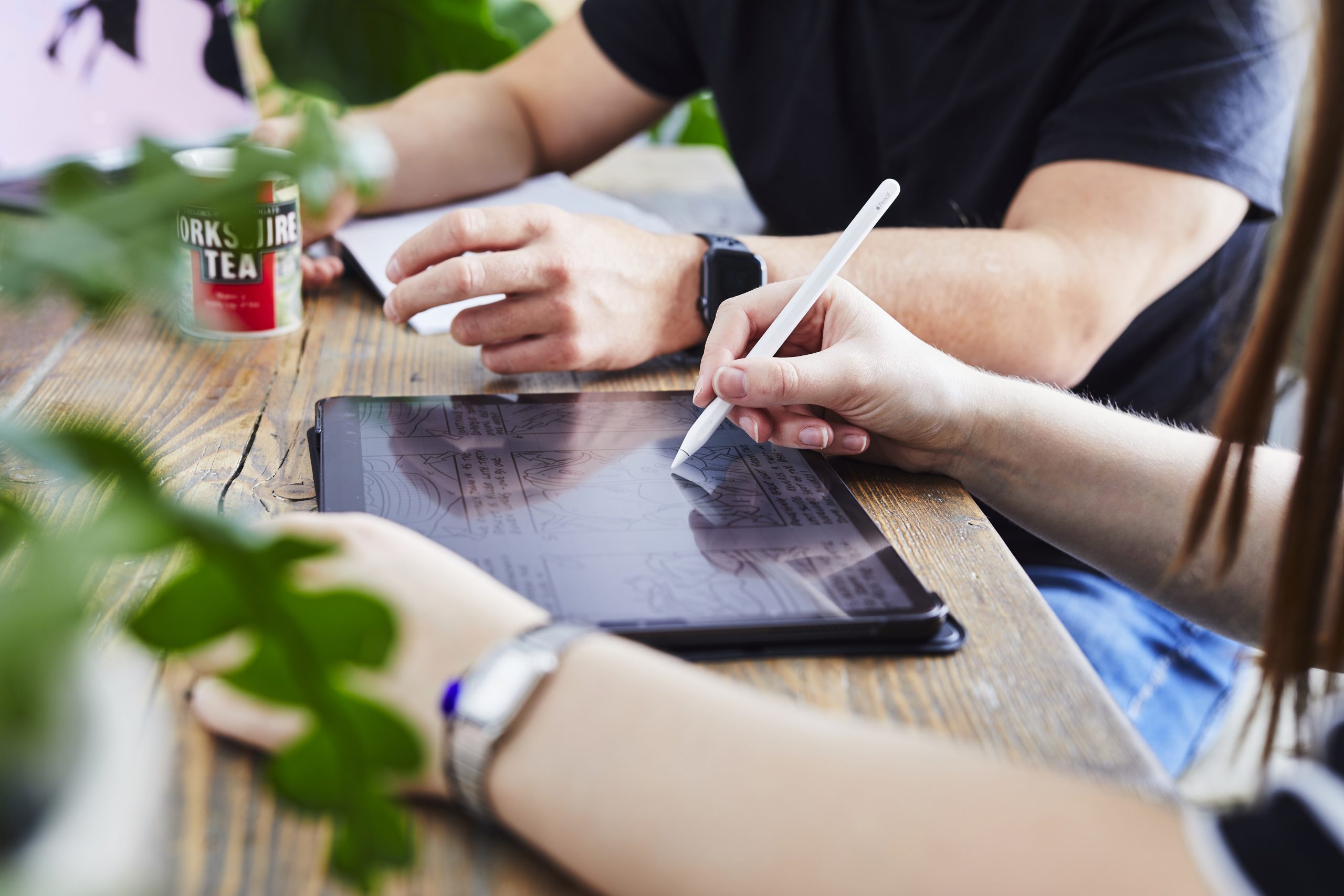 Employees drawing creative concepts on an iPad