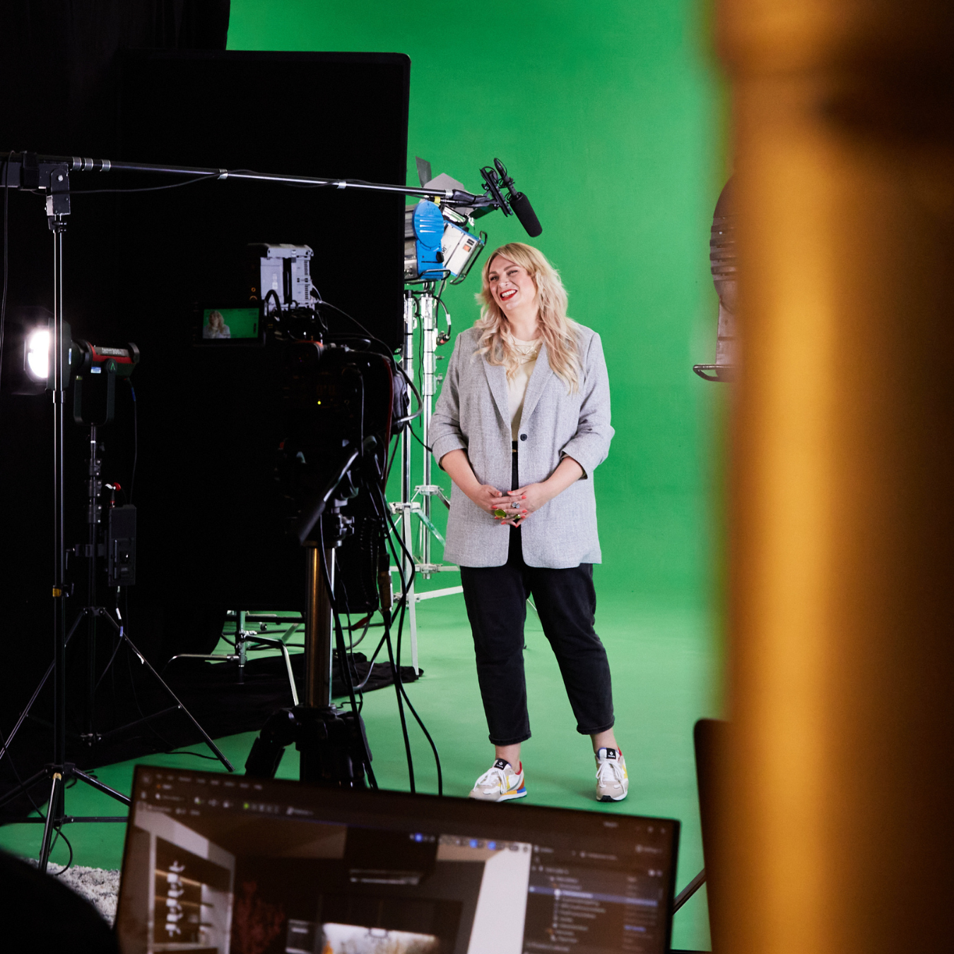 Woman in green screen studio being filmed using CGI in the background