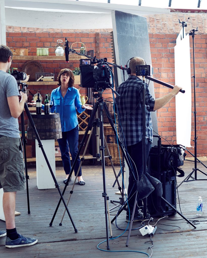 Behind the scenes of crew on set filming a woman